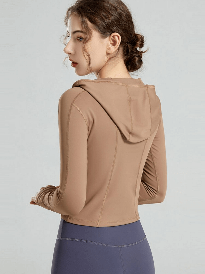 Back view of stylish women's sports top with long sleeves and hood, ideal for yoga. Made from breathable, quick-dry nylon and spandex.